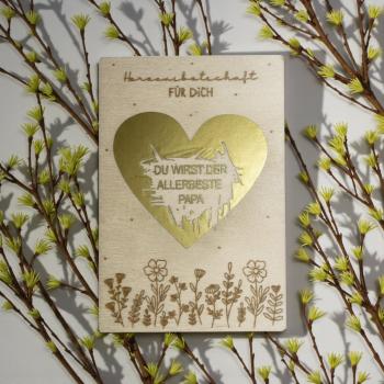 Preview: Holz‑Rubbelkarte zur Schwangerschaftsverkündung mit goldenem Rubbelherz.